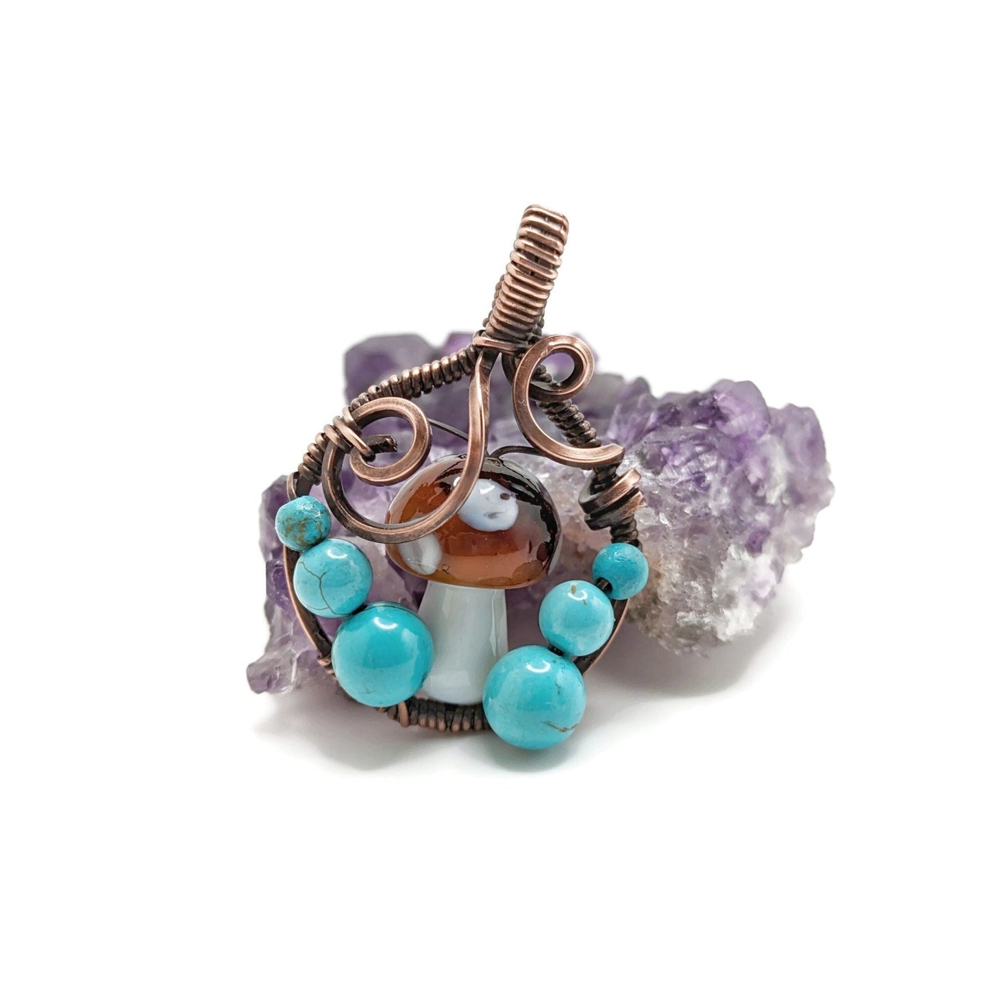 Round pendant with mushroom in the middle and bright blue turquoise howlite at its sides.