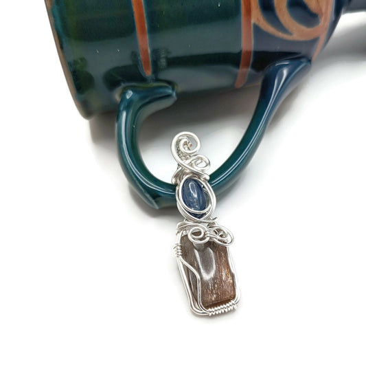 Sunstone and kyanite wrapped in a silver pendant.